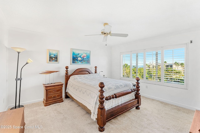 carpeted bedroom with ceiling fan and ornamental molding