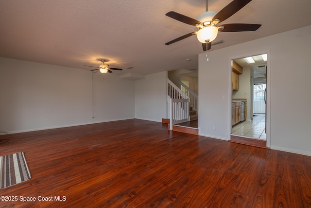 unfurnished living room featuring a textured ceiling, ceiling fan, and light wood-type flooring