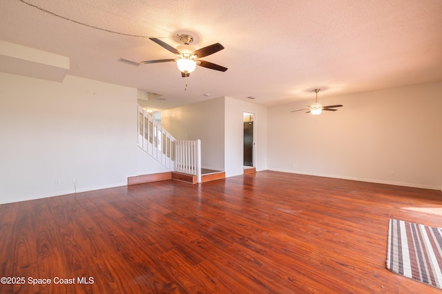 empty room featuring a textured ceiling, dark hardwood / wood-style floors, and ceiling fan