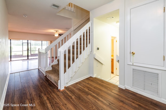 stairs featuring hardwood / wood-style flooring and ceiling fan