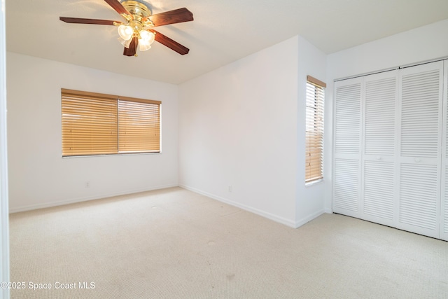 unfurnished bedroom with light colored carpet, a closet, and ceiling fan