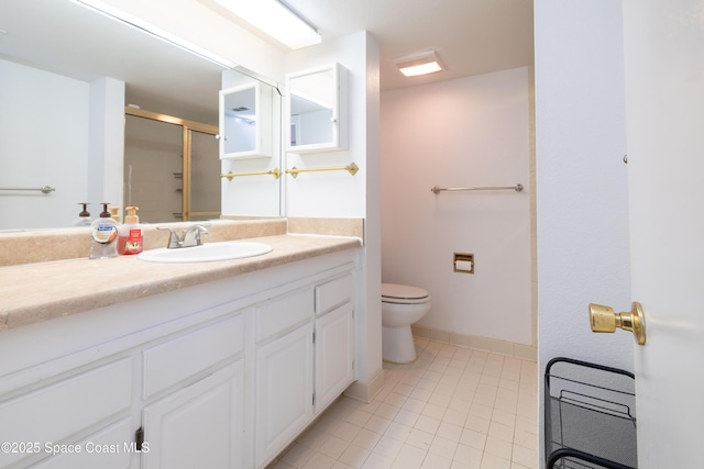 bathroom featuring tile patterned flooring, toilet, vanity, and a shower with shower door