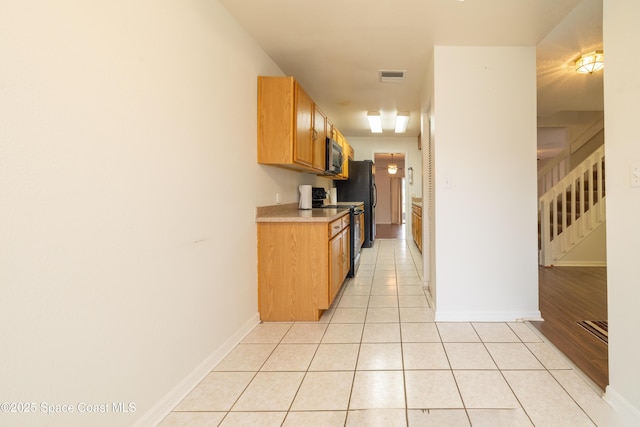 kitchen with electric range oven and light tile patterned floors