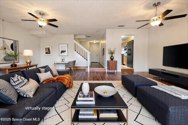 living room with ceiling fan and light hardwood / wood-style flooring