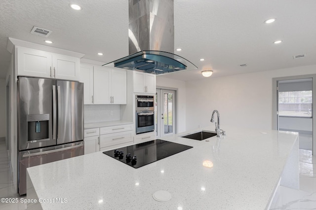 kitchen featuring sink, white cabinetry, stainless steel appliances, island range hood, and light stone countertops