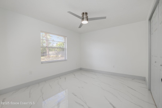 empty room featuring ceiling fan and a textured ceiling