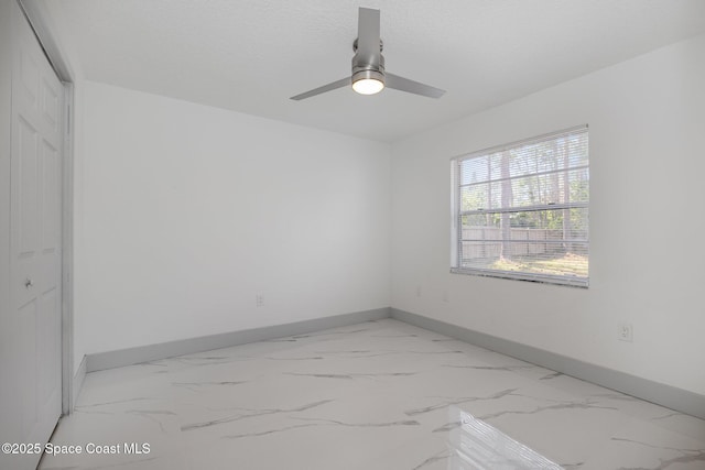 empty room with ceiling fan and a textured ceiling