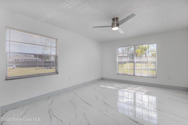 spare room with ceiling fan, a textured ceiling, and a healthy amount of sunlight