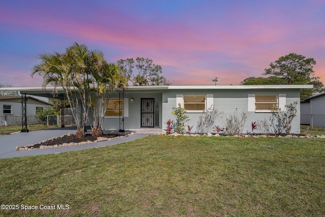 ranch-style home with a carport and a lawn