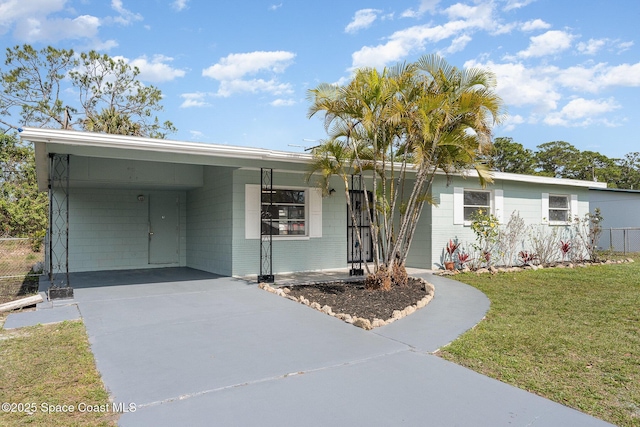 ranch-style house featuring a carport and a front yard