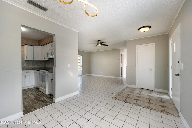 kitchen featuring light tile patterned flooring, white cabinets, white electric range oven, ceiling fan, and crown molding