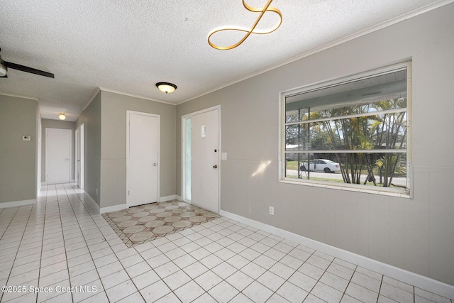 tiled foyer entrance featuring crown molding and a textured ceiling