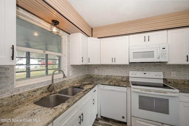 kitchen with sink, white appliances, white cabinets, and stone counters