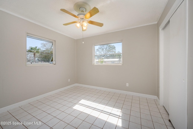 empty room featuring light tile patterned floors, crown molding, and ceiling fan