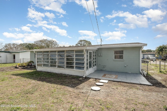 back of property with a patio, a yard, and a sunroom