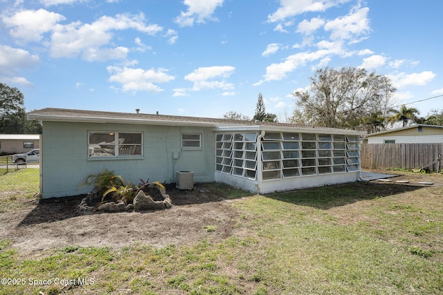 rear view of property featuring a yard, central AC, and a sunroom