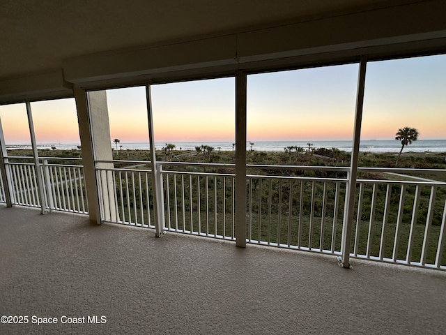 unfurnished sunroom featuring a water view and a healthy amount of sunlight