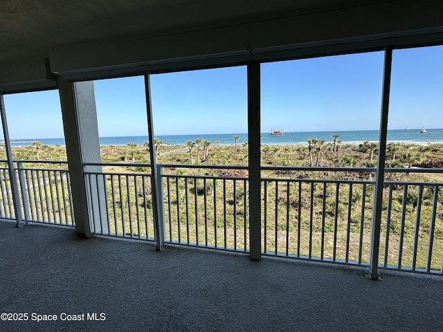 unfurnished sunroom featuring a water view