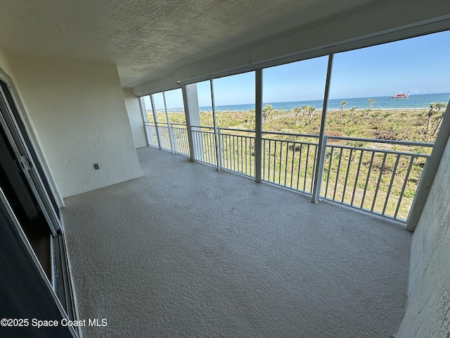 unfurnished sunroom featuring a water view