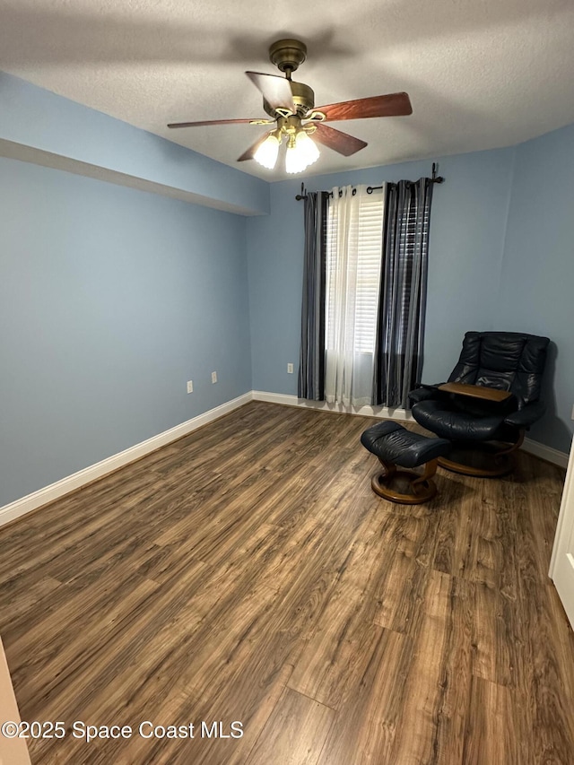 living area featuring ceiling fan, hardwood / wood-style floors, and a textured ceiling