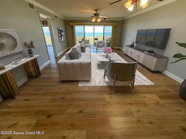 living room featuring ornamental molding, light hardwood / wood-style floors, and ceiling fan