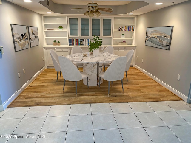 tiled dining space with built in shelves and ceiling fan