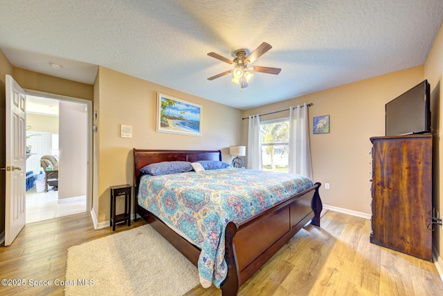 bedroom with ceiling fan, a textured ceiling, and light hardwood / wood-style floors