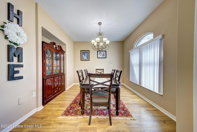 dining space featuring an inviting chandelier and light hardwood / wood-style floors