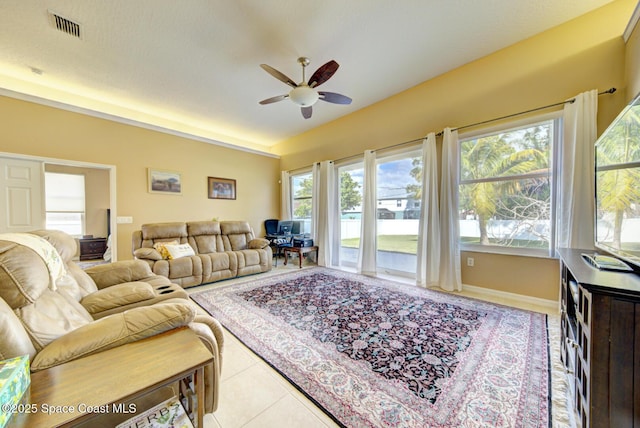 tiled living room with lofted ceiling and ceiling fan