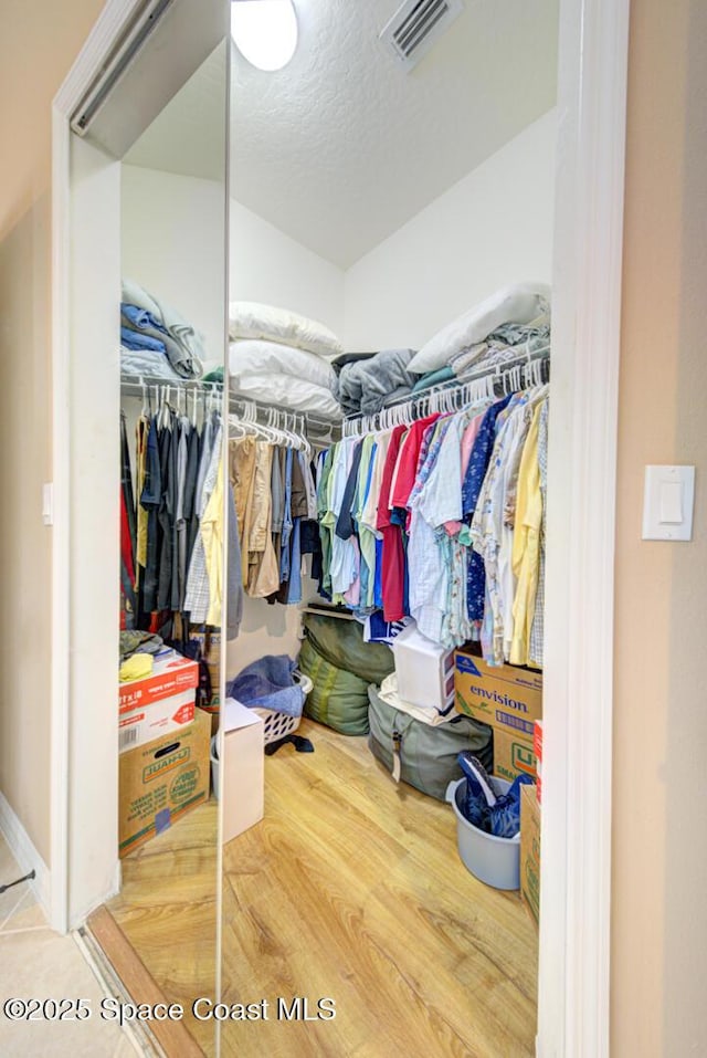 walk in closet with hardwood / wood-style floors