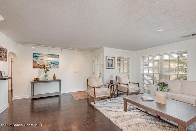 living room featuring dark hardwood / wood-style flooring, ornamental molding, rail lighting, and a textured ceiling