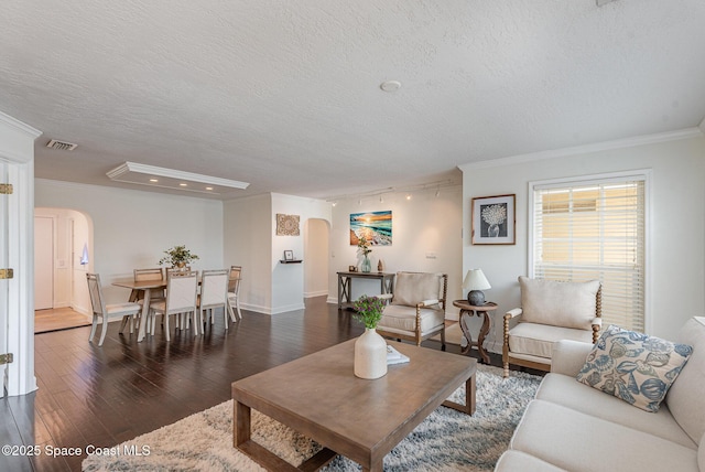 living room with crown molding, dark hardwood / wood-style floors, and a textured ceiling