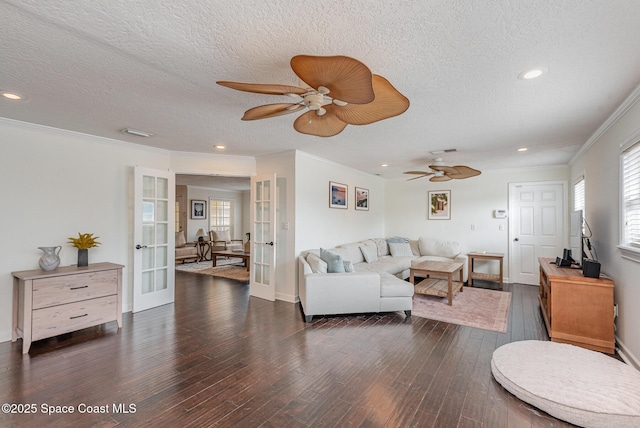 living room featuring ornamental molding, ceiling fan, dark wood-type flooring, a textured ceiling, and french doors