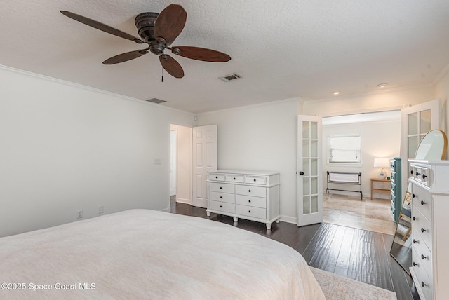 bedroom featuring ceiling fan, ornamental molding, a textured ceiling, dark hardwood / wood-style flooring, and french doors