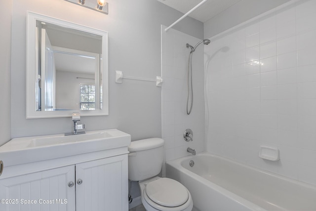 full bathroom with tiled shower / bath, vanity, and toilet