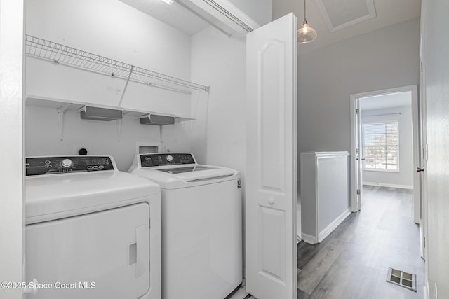 laundry area with washer and dryer and light wood-type flooring