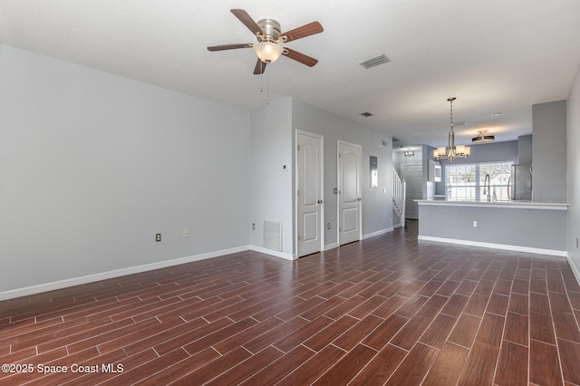 unfurnished living room with ceiling fan with notable chandelier