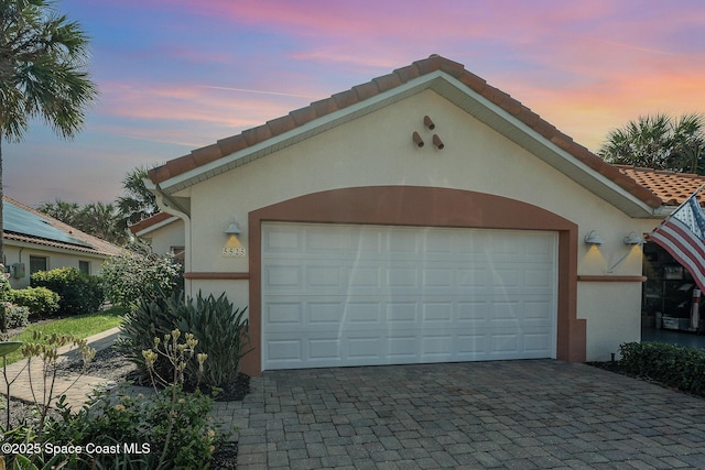 view of garage at dusk