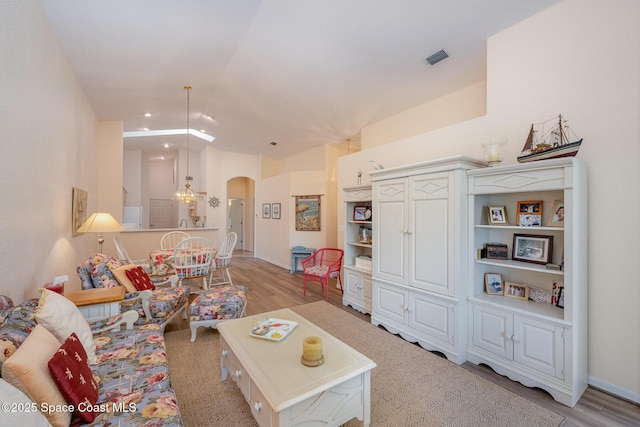 living room featuring vaulted ceiling and light hardwood / wood-style floors