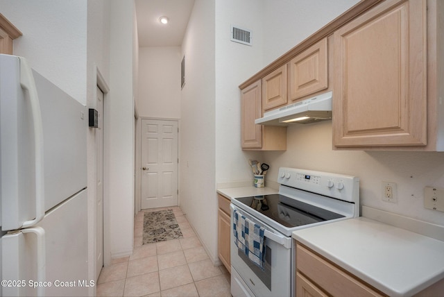 kitchen with light brown cabinetry, light tile patterned floors, and white appliances