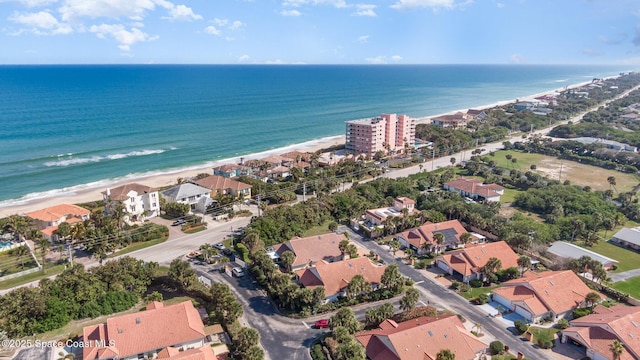 birds eye view of property with a water view and a beach view