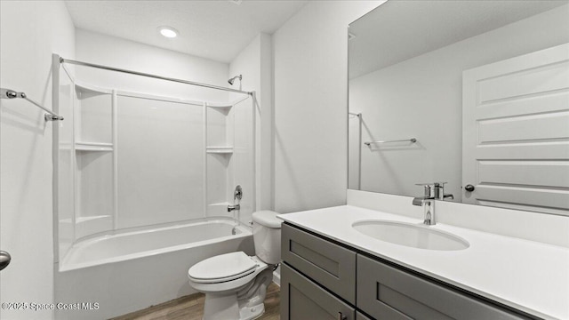 full bath with washtub / shower combination, vanity, wood finished floors, and toilet