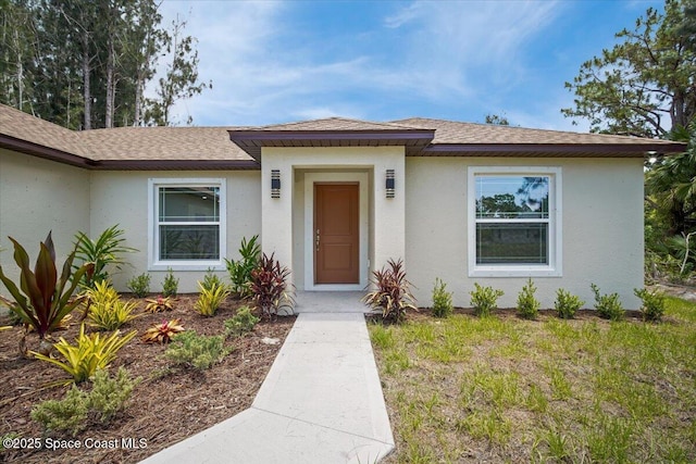 1305 Harper Blvd SW, Palm Bay, FL 32908 - view of exterior entry featuring roof with shingles and stucco siding