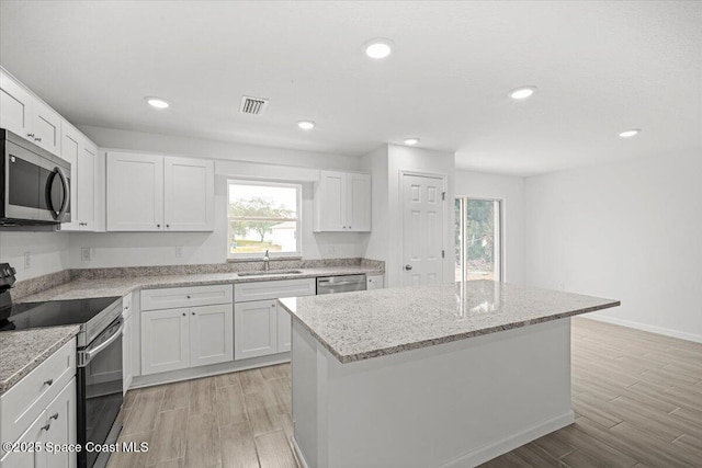1305 Harper Blvd SW, Palm Bay, FL 32908 - kitchen featuring appliances with stainless steel finishes, a sink, light wood-style floors, white cabinetry, and recessed lighting