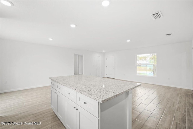 1305 Harper Blvd SW, Palm Bay, FL 32908 - kitchen with wood tiled floors, a center island, baseboards, open floor plan, and recessed lighting