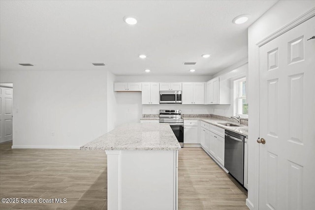 1305 Harper Blvd SW, Palm Bay, FL 32908 - kitchen featuring stainless steel appliances, a sink, a kitchen island, baseboards, and recessed lighting