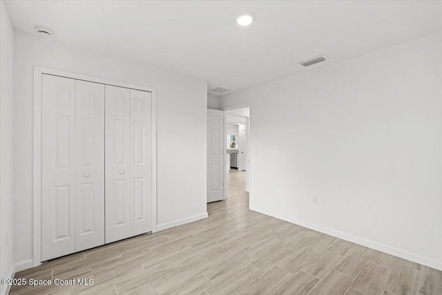 1305 Harper Blvd SW, Palm Bay, FL 32908 - unfurnished bedroom with light wood-type flooring, baseboards, a closet, and recessed lighting