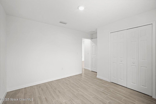 1305 Harper Blvd SW, Palm Bay, FL 32908 - unfurnished bedroom featuring light wood finished floors, baseboards, and a closet