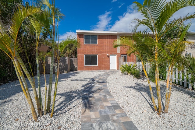 view of front of property with fence and brick siding