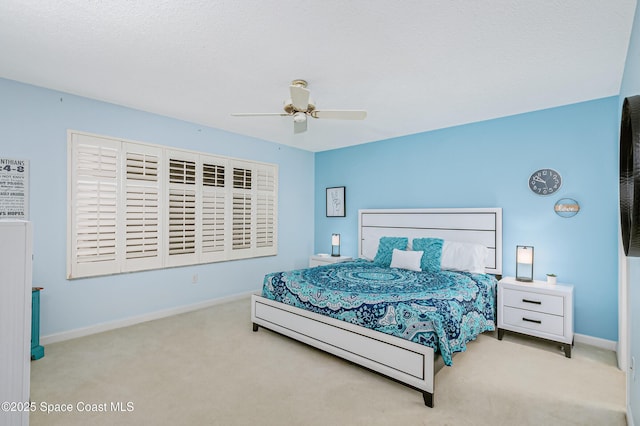 carpeted bedroom with ceiling fan and baseboards